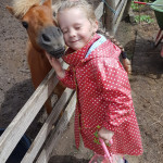 kleines Mädchen kuschelt mit Pony